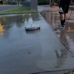 Supreme Clean pressure washing a concrete walkway with a surface cleaner