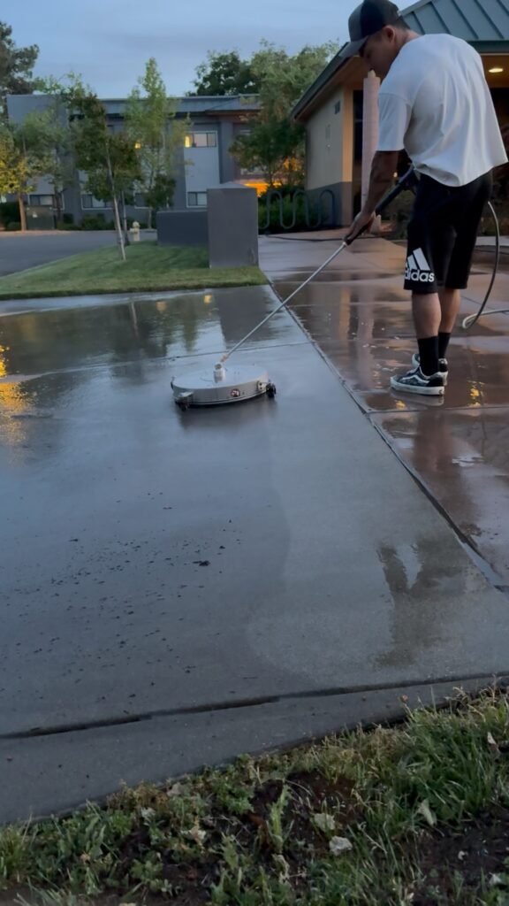 Supreme Clean pressure washing a concrete walkway with a surface cleaner