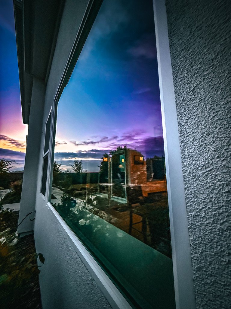 Spotless residential window reflecting a sunset after Supreme Clean service